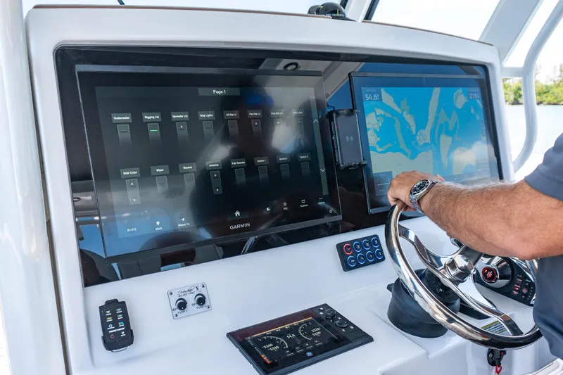 Slide: The Image of Control panel of 2026 Twin Vee 400 GFX2 CC boat with navigation screens and steering wheel. - 39