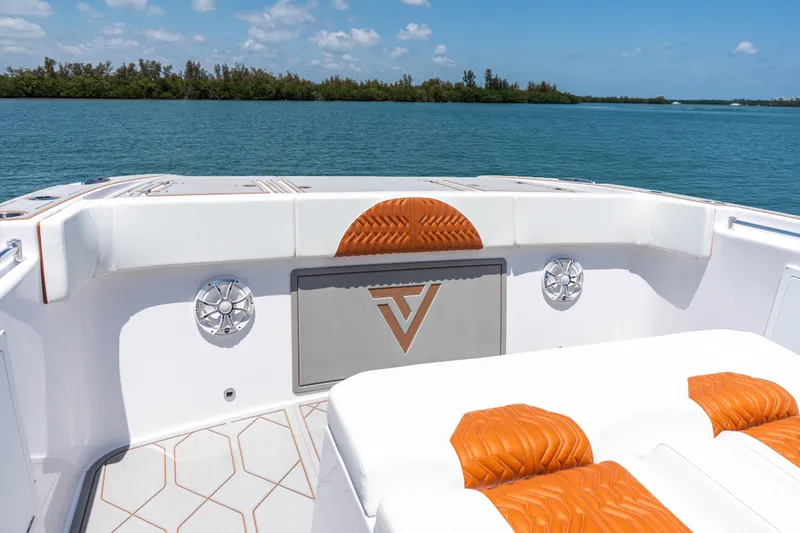 Slide: The Image of 2026 Twin Vee 400 GFX2 CC boat interior with orange accents, on a serene water backdrop. - 9