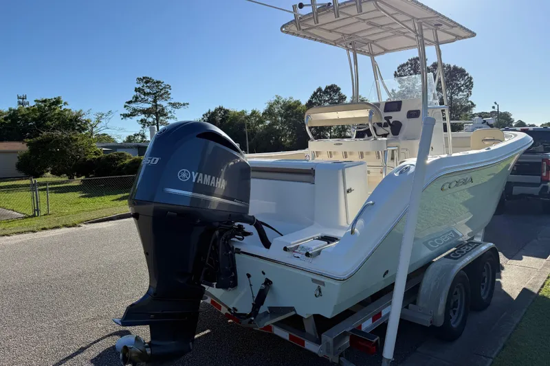 Slide: The Image of 2018 Cobia 220 Center Console boat with Yamaha engine on trailer, parked outdoors. - 6