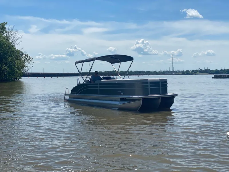 The Image of 2024 Harris 250CX pontoon boat on calm water. - 1