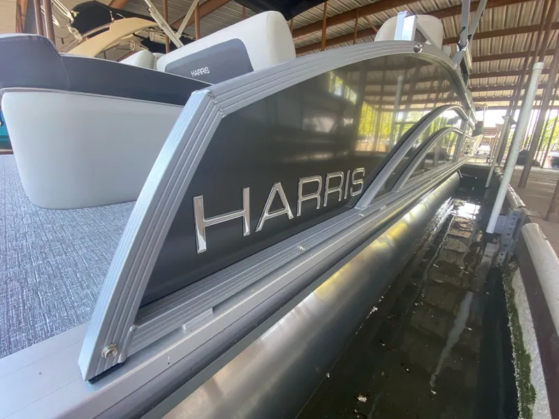 Slide: The Image of 2024 Harris 250CX pontoon boat docked, close-up of logo. - 10