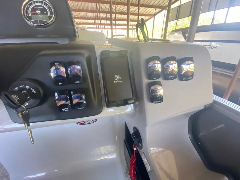 Slide: The Image of Dashboard of 2024 Harris 250CX boat with switches and ignition key. - 12