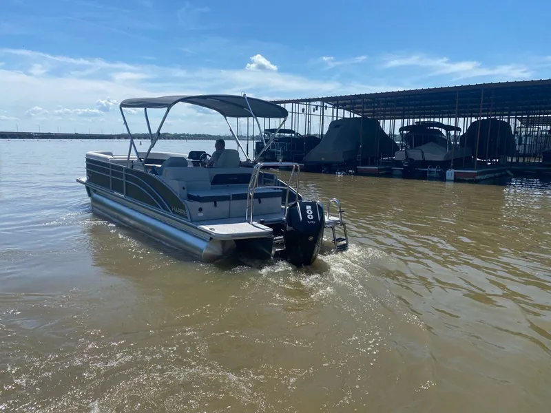 Slide: The Image of 2024 Harris 250CX pontoon boat on a sunny lake. - 3