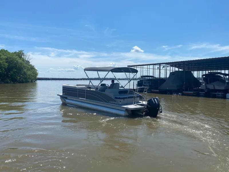 Slide: The Image of 2024 Harris 250CX pontoon boat on a sunny lake. - 4