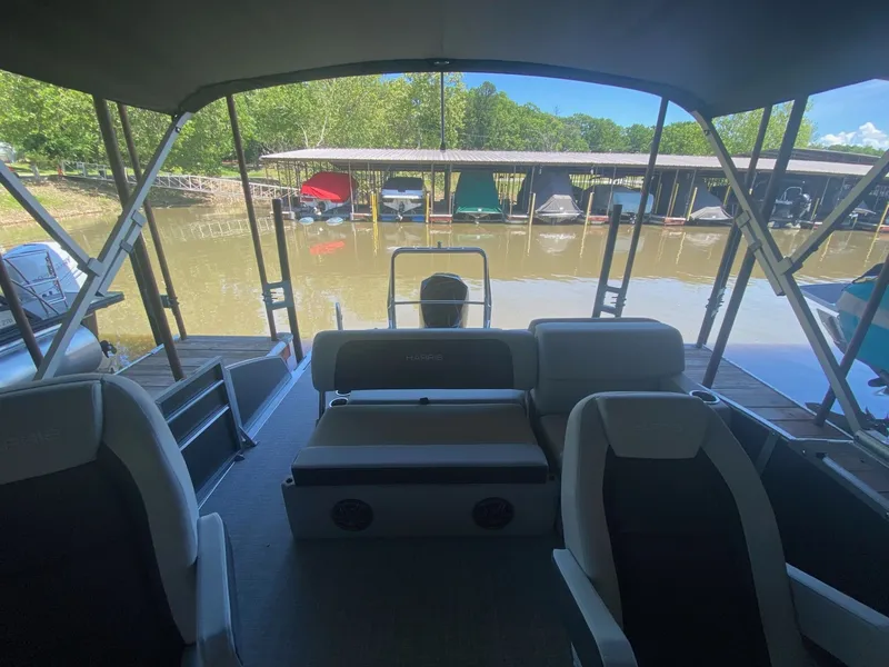 Slide: The Image of Interior view of a 2024 Harris 250CX pontoon boat at dock. - 8