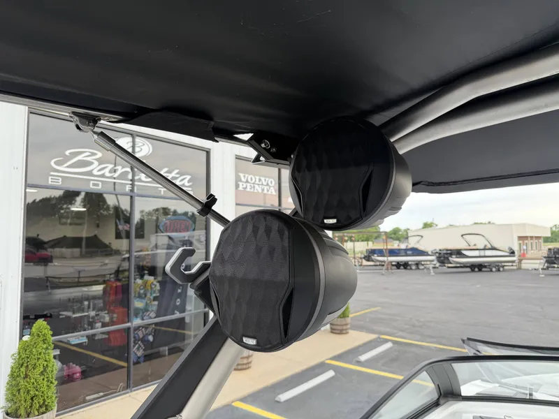 Slide: The Image of Speakers on a 2023 Malibu 26LSV boat, parked outdoors. - 27