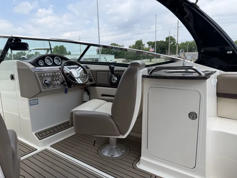 Slide: The Image of Interior of a 2013 Sea Ray 250SLX with helm console and seating. - 12