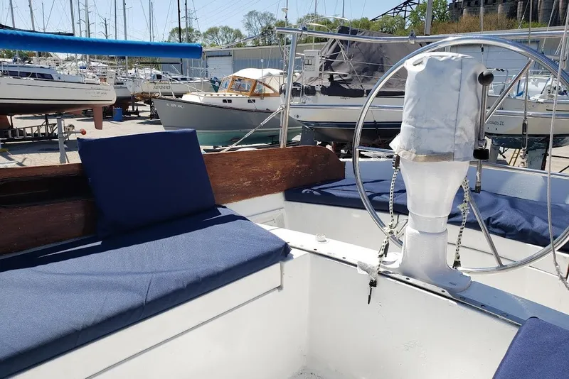 Slide: The Image of Cockpit of a 1974 Ericson 32-2 sailboat with blue cushions and steering wheel. - 12