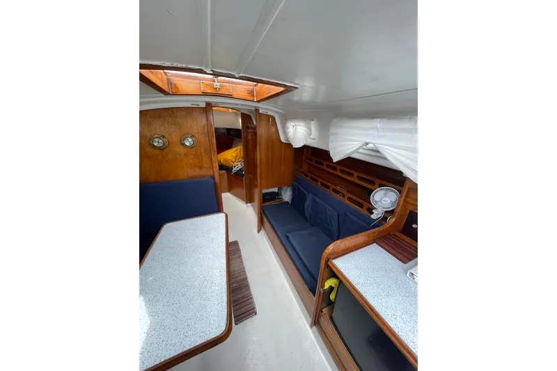 Slide: The Image of Interior of a 1974 Ericson 32-2 sailboat with wood paneling and blue seating. - 15