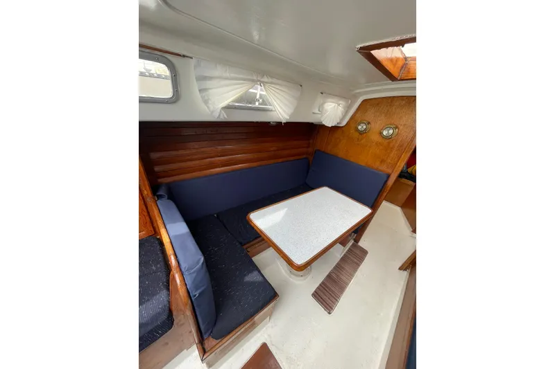 Slide: The Image of Interior of a 1974 Ericson 32-2 sailboat with wooden seating and table. - 16