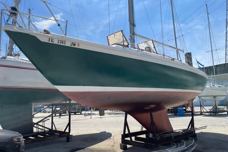 Slide: The Image of 1974 Ericson 32-2 sailboat on dry dock, green hull, sunny day, marina background. - 2