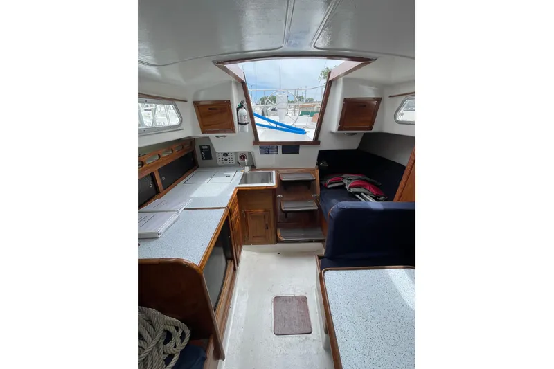 Slide: The Image of Interior of a 1974 Ericson 32-2 sailboat with wooden cabinetry and seating. - 24
