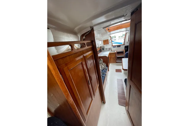Slide: The Image of Interior view of a 1974 Ericson 32-2 sailboat, featuring wooden cabinetry and seating area. - 26