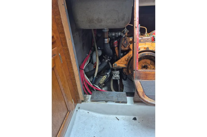 Slide: The Image of Engine compartment of a 1974 Ericson 32-2 sailboat, showing mechanical components and wiring. - 30