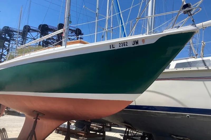 Slide: The Image of 1974 Ericson 32-2 sailboat with green hull and white trim, docked on land. - 4
