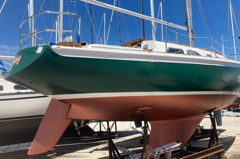 Slide: The Image of 1974 Ericson 32-2 sailboat with green hull and red keel on dry dock. - 5