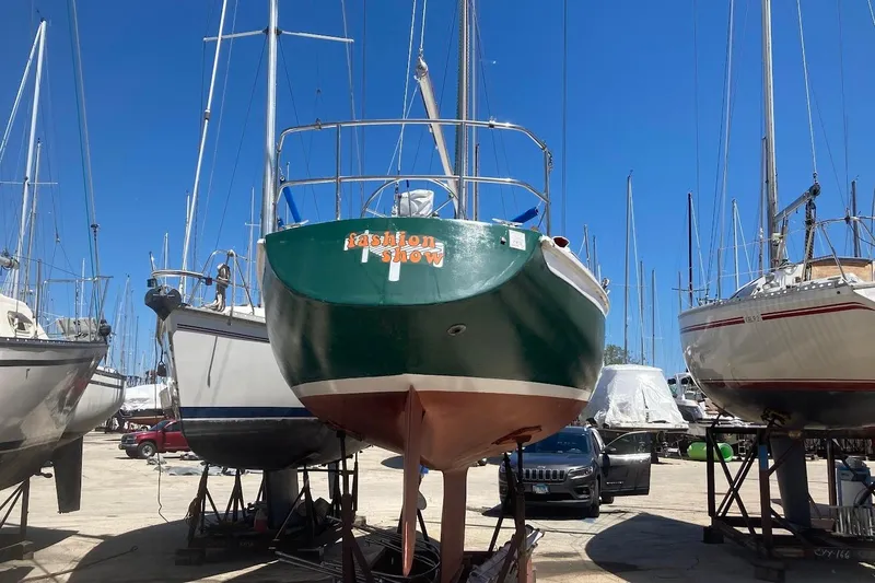 Slide: The Image of 1974 Ericson 32-2 sailboat in dry dock, surrounded by other boats under a clear blue sky. - 6