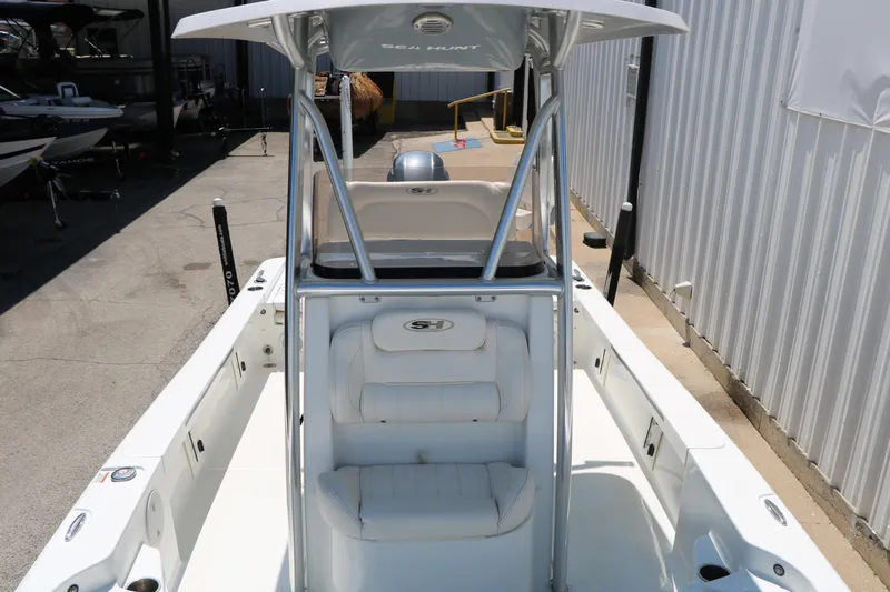 Slide: The Image of 2016 Sea Hunt BX 22 BR boat with T-top and seating, docked outdoors. - 27