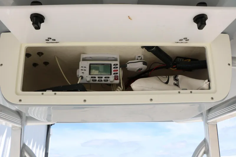 Slide: The Image of 2016 Sea Hunt BX 22 BR boat storage compartment with electronic equipment and wiring. - 38