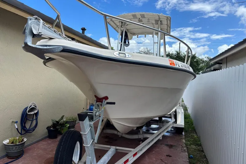 The Image of 2004 Key West 2220 Center Console boat on trailer, parked beside a house. - 0