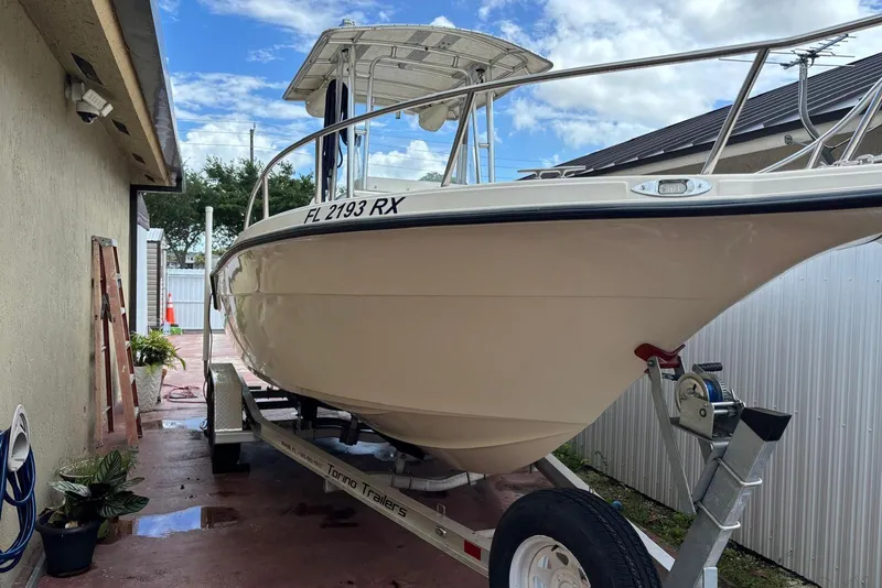 Slide: The Image of 2004 Key West 2220 Center Console boat on trailer, parked beside a building. - 2