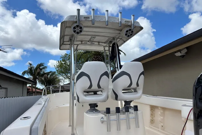 Slide: The Image of 2004 Key West 2220 Center Console boat with dual seats and rod holders under a blue sky. - 4