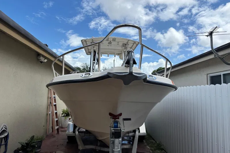Slide: The Image of 2004 Key West 2220 Center Console boat parked between buildings under a blue sky. - 7