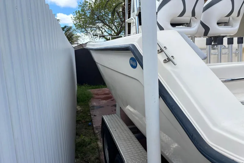 Slide: The Image of 2004 Key West 2220 Center Console boat parked beside a white fence. - 8