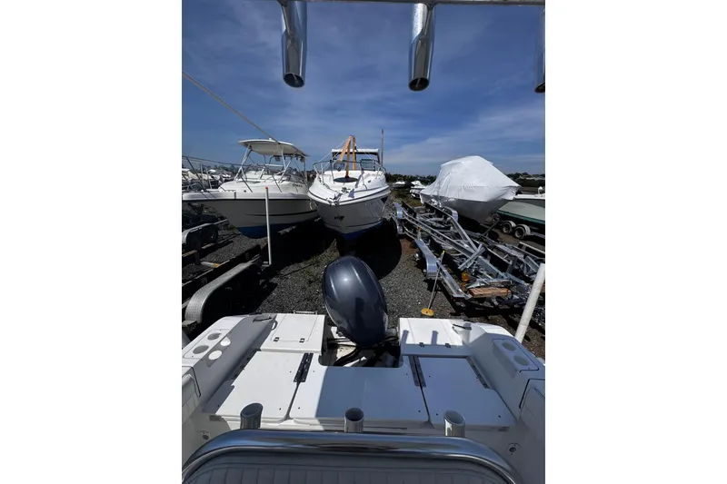 Slide: The Image of Boats in storage yard, featuring a 2017 Release 210RX model under a clear blue sky. - 10