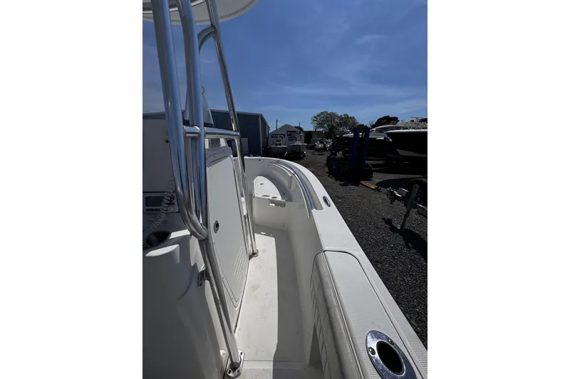 Slide: The Image of 2017 Release 210RX boat deck with stainless steel railings under clear blue sky. - 13