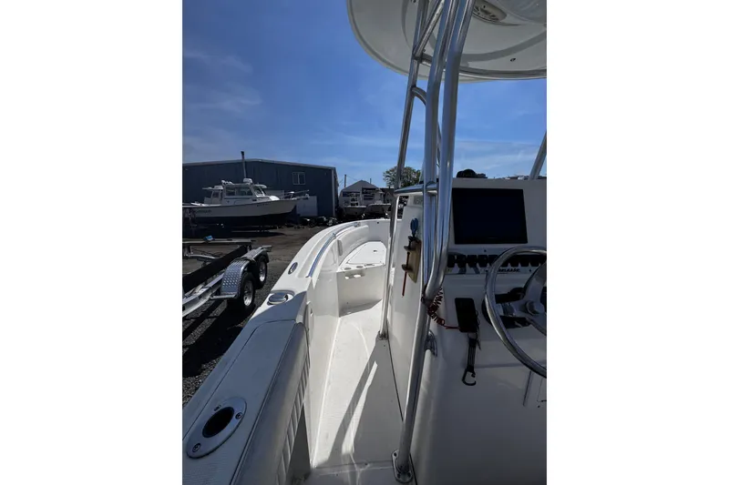 Slide: The Image of 2017 Release 210RX boat interior with steering console, docked near other boats. - 14