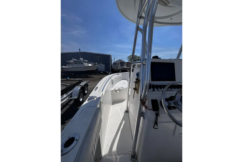 Slide: The Image of 2017 Release 210RX boat interior with steering console and docked boats in background. - 15