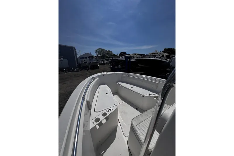 Slide: The Image of 2017 Release 210RX boat interior with seating, parked outdoors under a clear sky. - 16