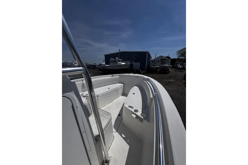 Slide: The Image of 2017 Release 210RX boat interior with seating, docked under clear blue sky. - 17