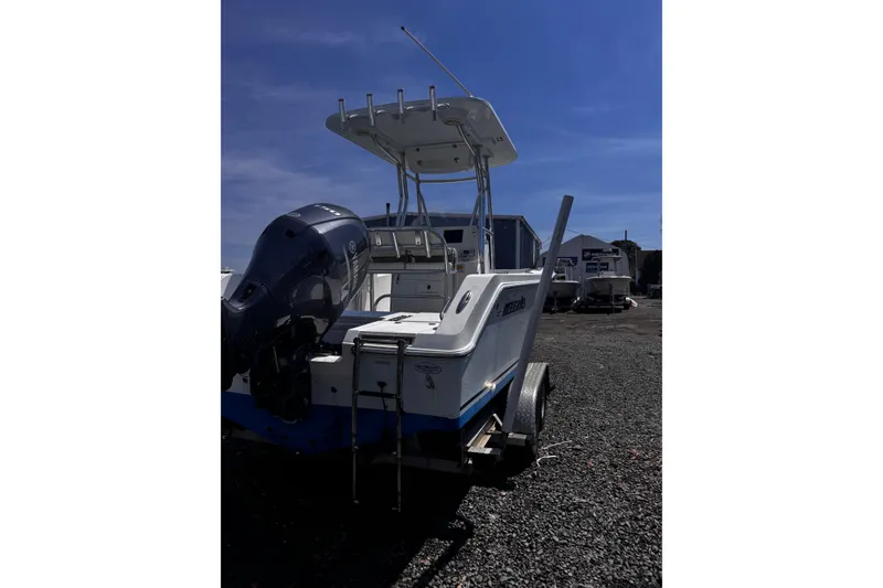 Slide: The Image of 2017 Release 210RX boat on trailer with outboard motor, parked on gravel lot. - 4