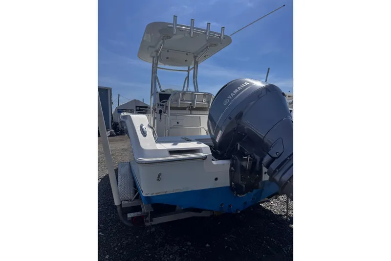 Slide: The Image of 2017 Release 210RX boat with Yamaha outboard motor, parked outdoors under clear blue sky. - 6