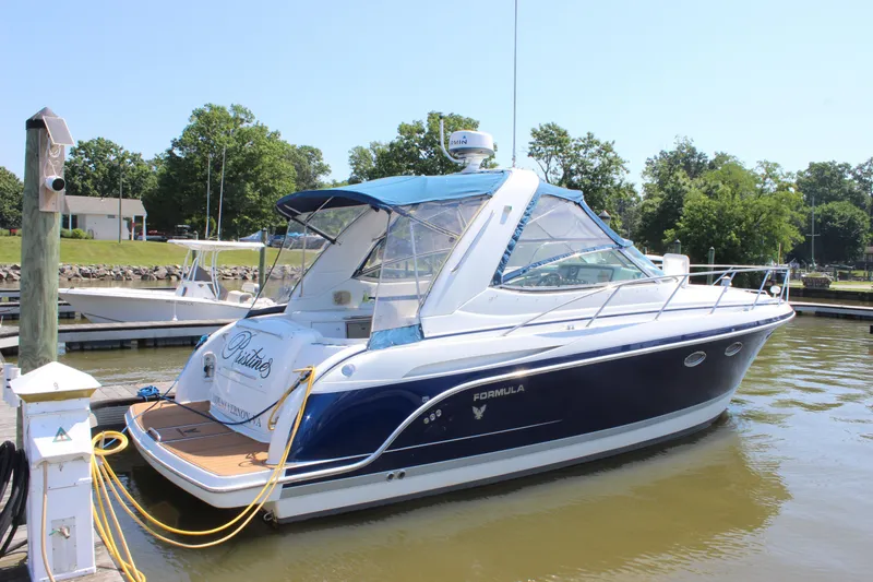 The Image of 2005 Formula 31 Performance Cruiser docked at marina, featuring sleek design and blue accents. - 1