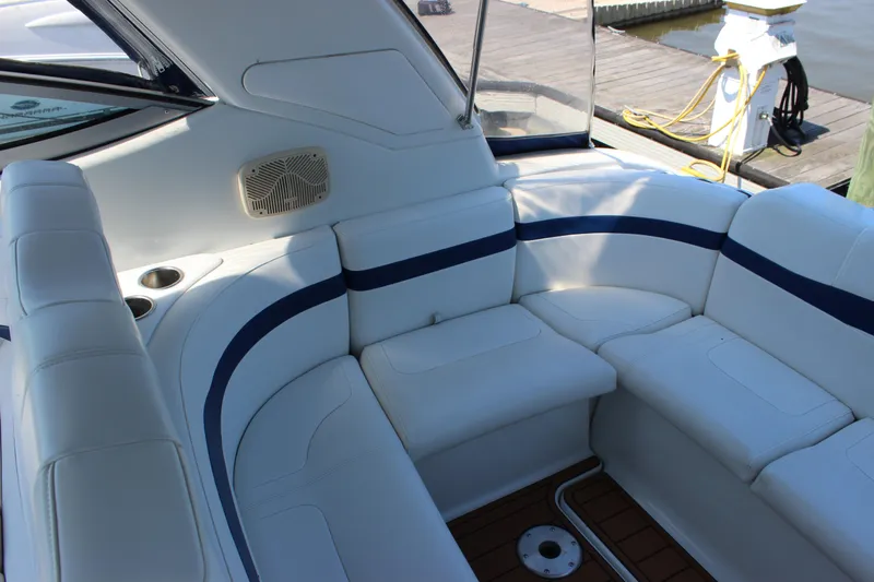 Slide: The Image of 2005 Formula 31 Performance Cruiser interior with white seating and blue accents at a dock. - 17