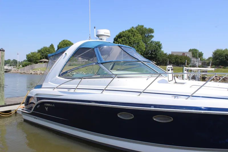 Slide: The Image of 2005 Formula 31 Performance Cruiser docked by a scenic waterfront. - 2