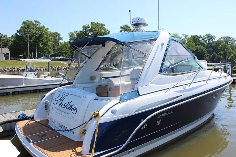 Slide: The Image of 2005 Formula 31 Performance Cruiser docked at marina, featuring sleek design and blue accents. - 32