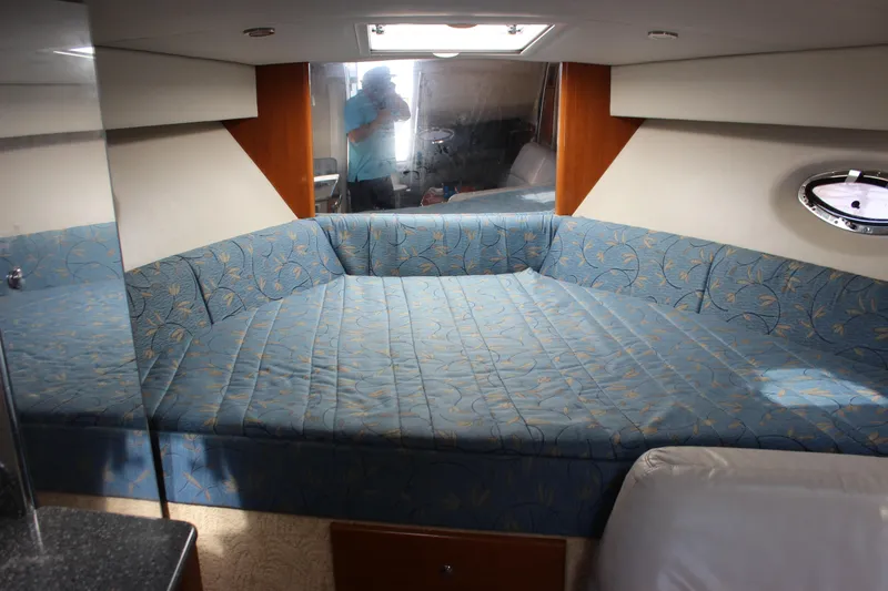 Slide: The Image of 2005 Formula 31 Performance Cruiser interior with blue patterned bedding and porthole window. - 52