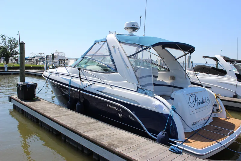 Slide: The Image of 2005 Formula 31 Performance Cruiser docked at marina, featuring blue canopy and sleek design. - 9