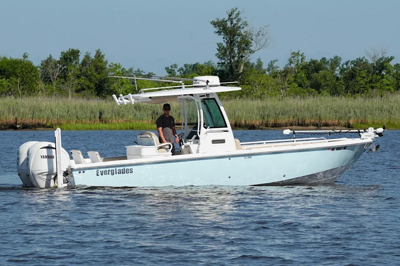 Slide: The Image of 2019 Everglades 273 Center Console boat cruising on a calm river. - 10