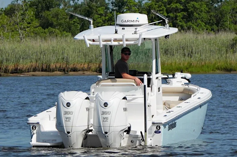 Slide: The Image of 2019 Everglades 273 Center Console boat with dual Yamaha engines on a calm waterway. - 11