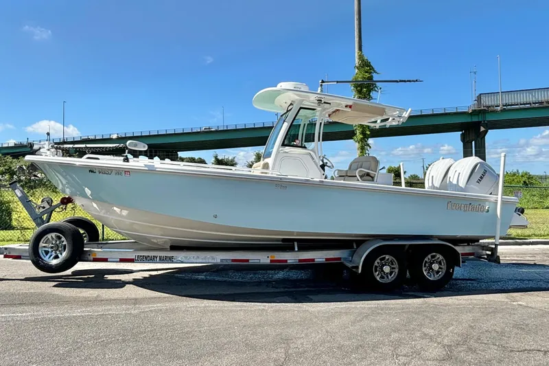 Slide: The Image of 2019 Everglades 273 Center Console boat on trailer, parked outdoors under a clear sky. - 13