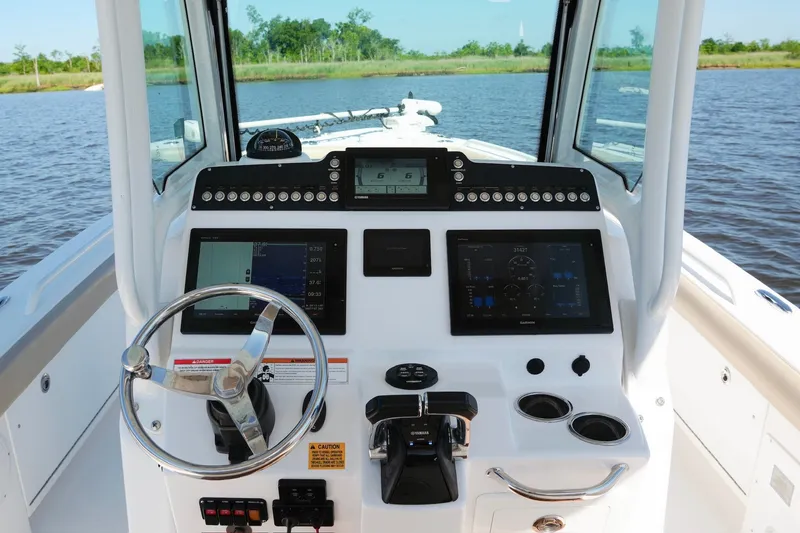 Slide: The Image of 2019 Everglades 273 Center Console boat dashboard with steering wheel and navigation screens. - 15