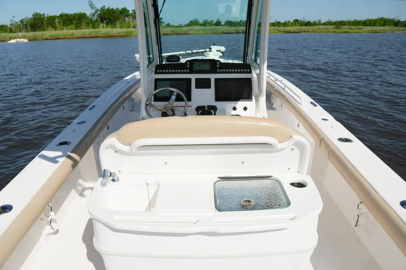 Slide: The Image of 2019 Everglades 273 Center Console boat on calm water, featuring a sleek design and modern controls. - 17