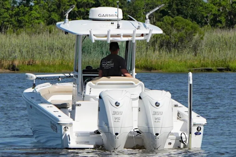 Slide: The Image of 2019 Everglades 273 Center Console boat with dual Yamaha engines on a calm waterway. - 2