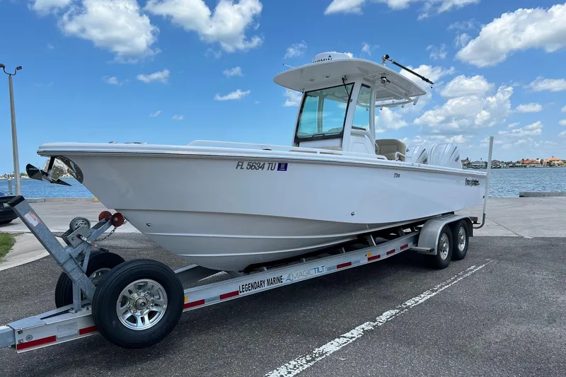 Slide: The Image of 2019 Everglades 273 Center Console boat on trailer by waterfront under blue sky. - 23