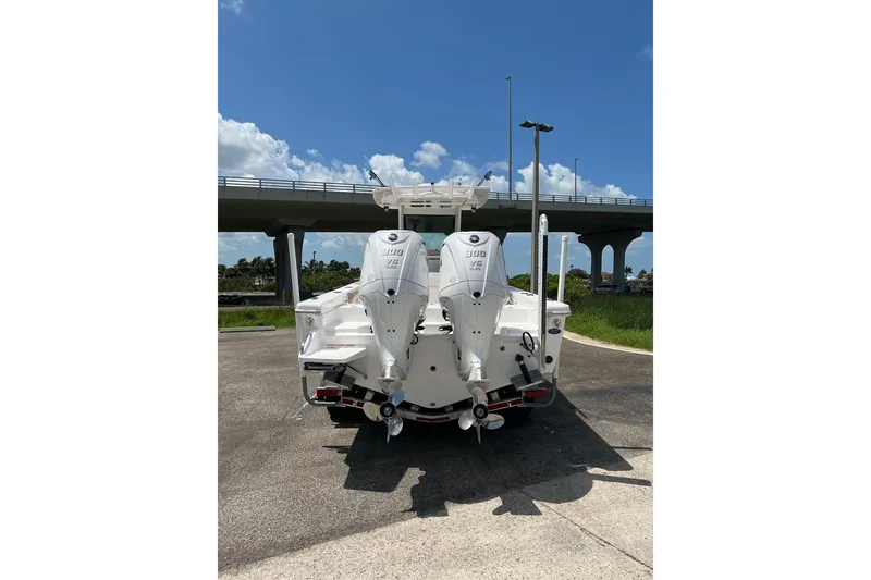 Slide: The Image of 2019 Everglades 273 Center Console boat with twin outboard engines, parked under a bridge. - 26
